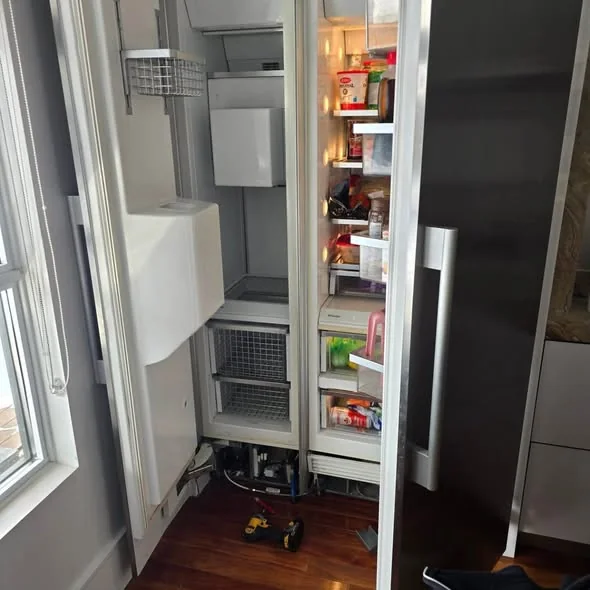 Sub-Zero built-in refrigerator kickplate removed with compressor service tools in Beacon Hill Boston