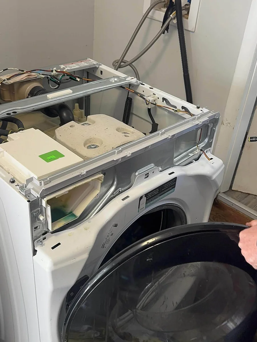 Front-load washing machine disassembled showing electronic control board and detergent dispenser in Charlestown Boston